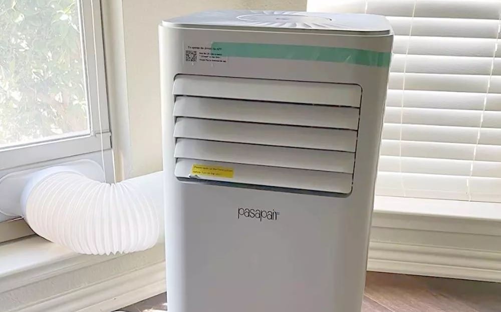 white portable air conditioner by the window
