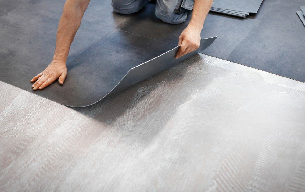 Worker laying vinyl flooring